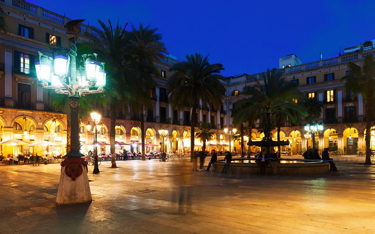 Placa Reial with fountain and restaurants in evening. Barcelona