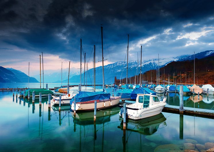 Boats and yachts on lake Thun at night.